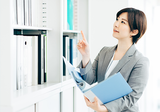 記帳代行サービスのイメージ - プロフェッショナルな女性がオフィスで書類を整理している様子